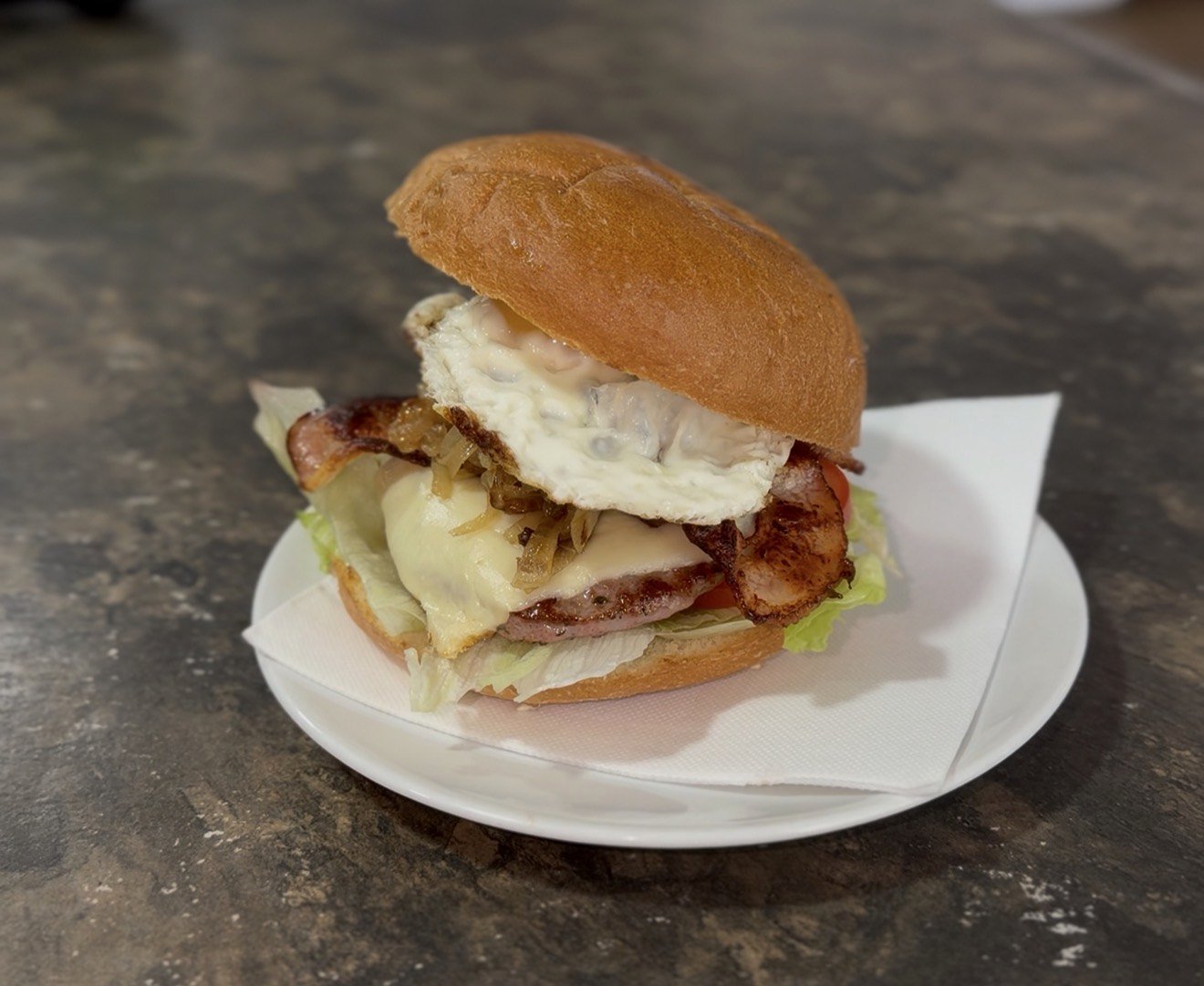 Hamburguesa Corner con huevo frito, bacon, queso, cebolla y lechuga